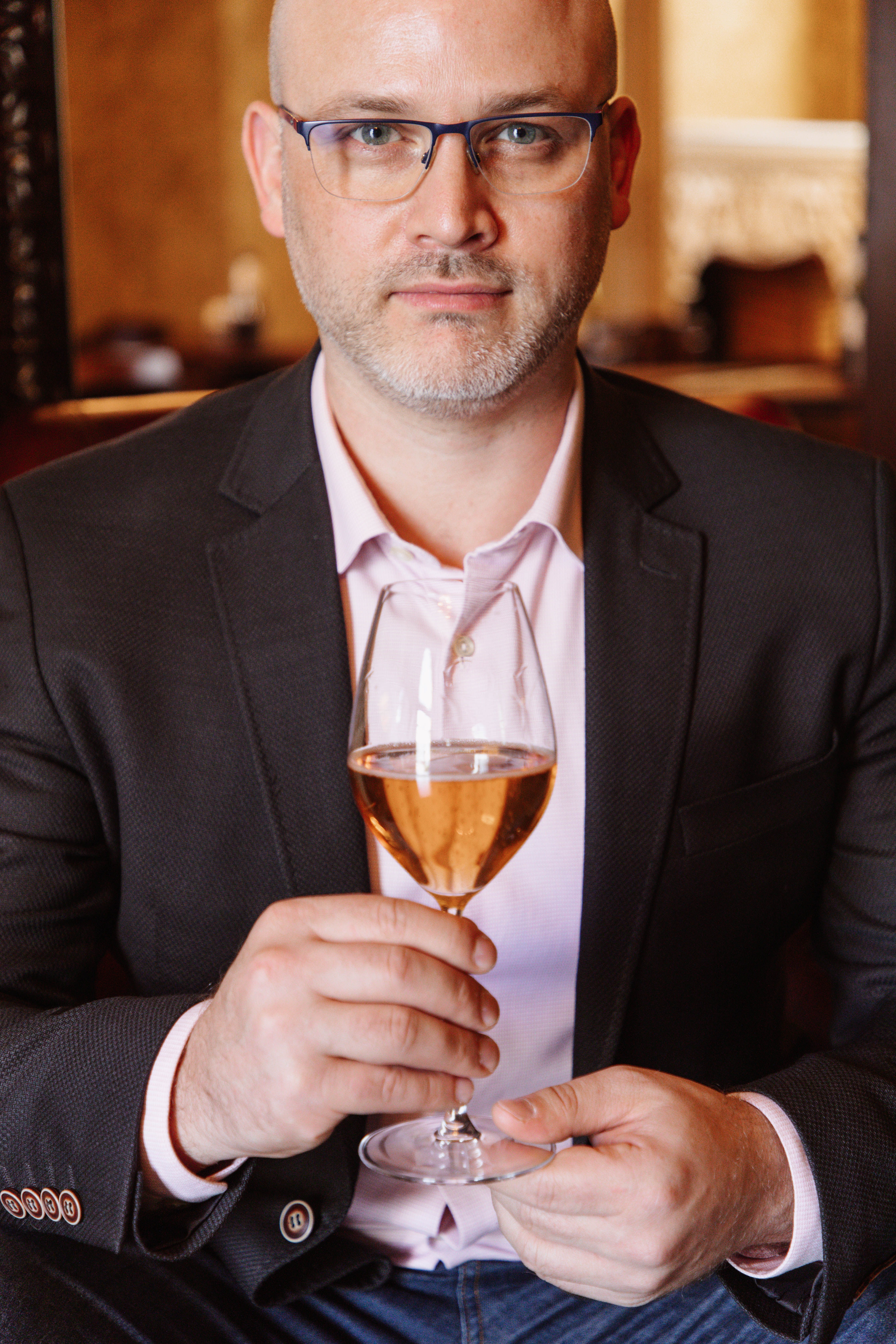 Prof. Júlio César Kunz segurando uma taça de vinho
